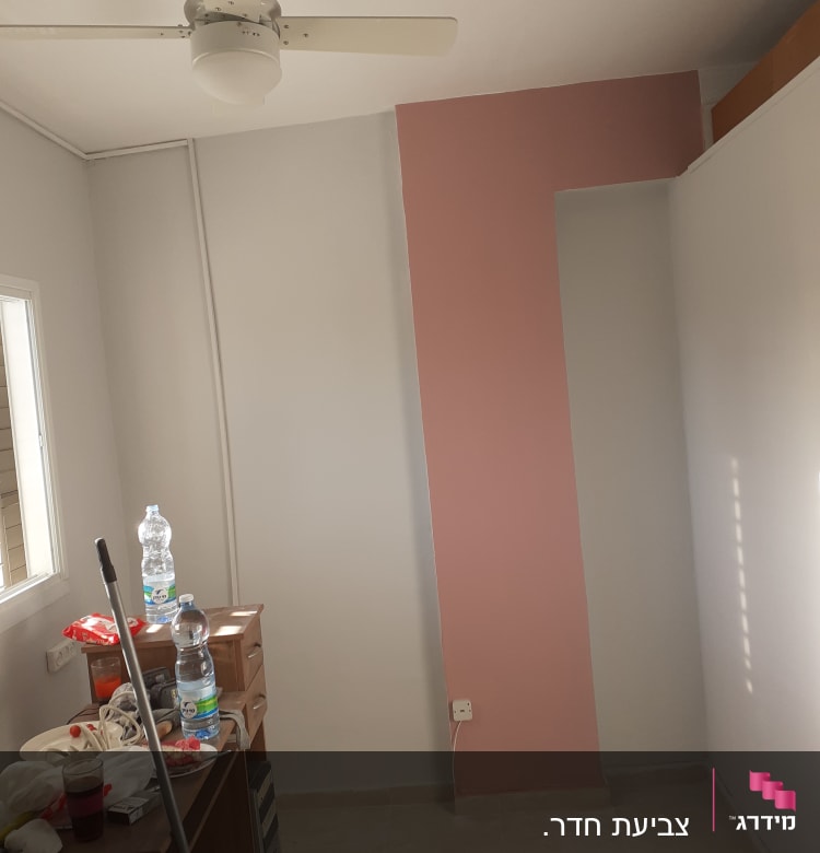 קיר צבוע בחלקו בצבע ורוד בחדר